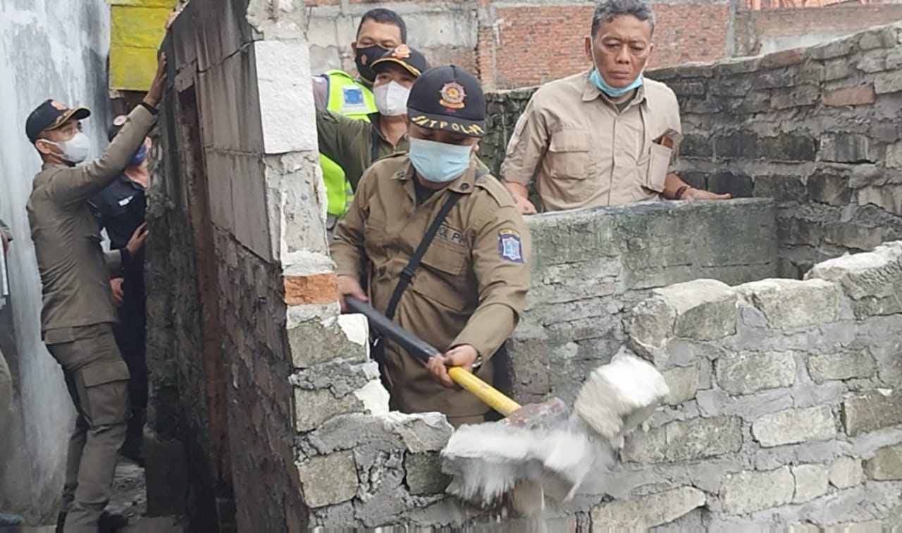 petugas gabungan saat bongkar paksa bilik bangunan di Sidokare Semampir dan amankan bekas alat hisap narkoba